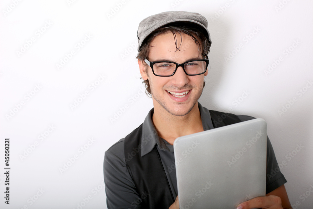 Closeup of smiling funky guy using tablet
