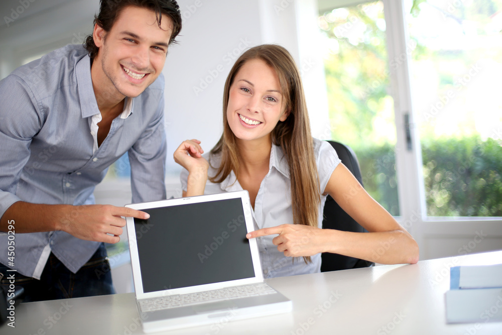 Successful business team showing laptop screen Successful business team showing laptop screen