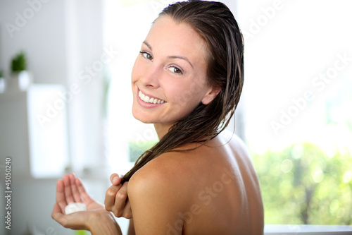Photos Gorgeous woman putting conditioner in her hair