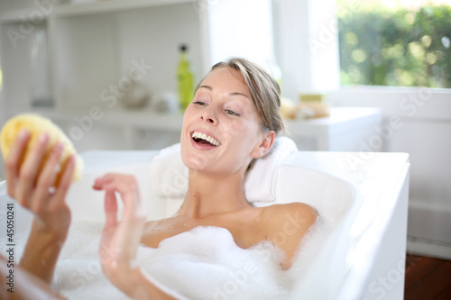 Beautiful woman using bath sponge