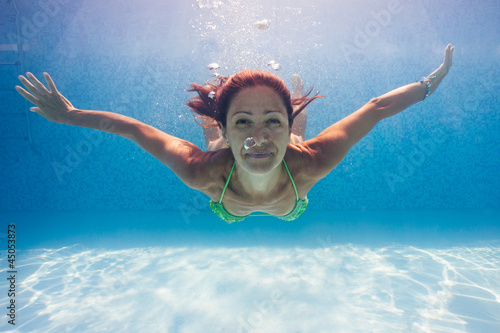 Underwater woman portrait in swimming pool.