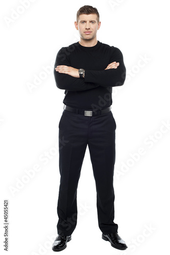 Young smart bouncer posing with his arms crossed .