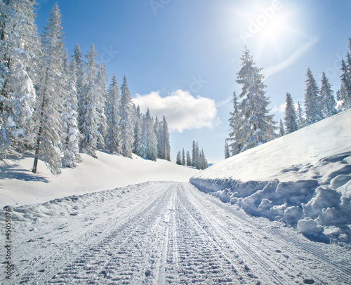 Empty snow covered road in winter landscape