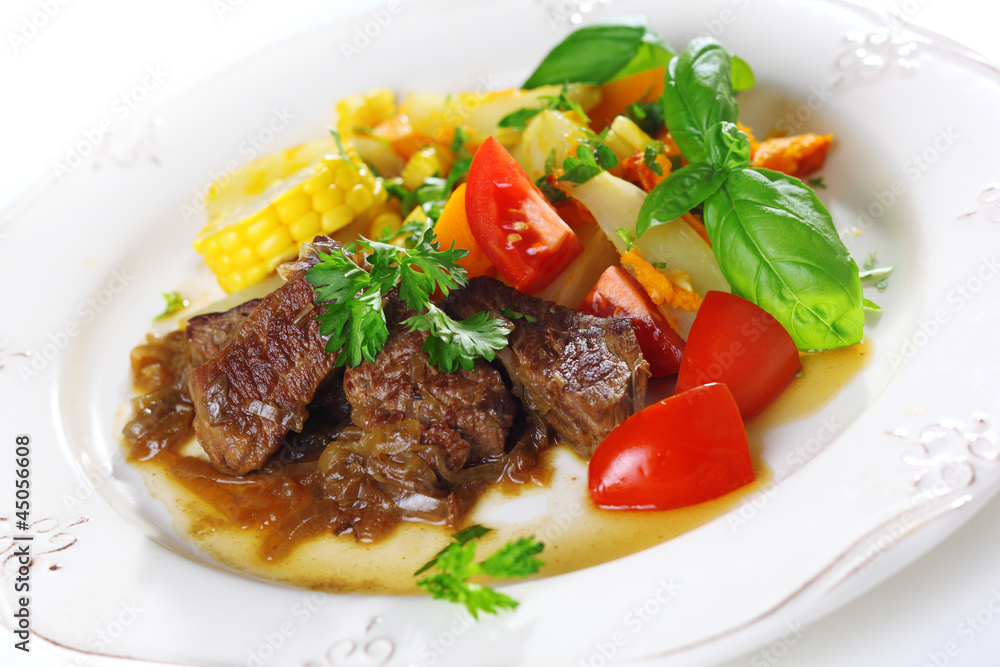 Traditional goulash or beef stew with vegetables and salad of fr Traditional goulash or beef stew with vegetables and salad of fr