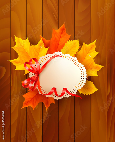 Card with leaves with a bow on wooden background