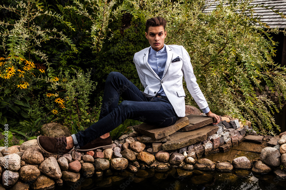 Fototapeta premium young beautiful fashionable man against autumn garden.