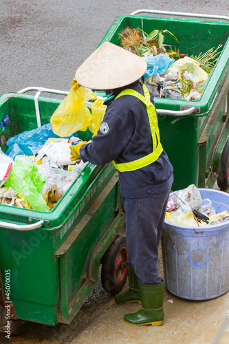 DA LAT, VIETNAM - 28 JULY 2012: Worker separates waste photo