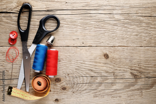 Foto Sewing accessories on wooden background