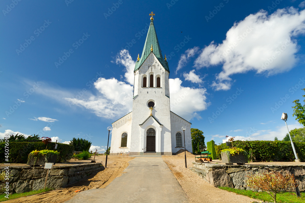 Traditional Swedish white church over sunny blue sky