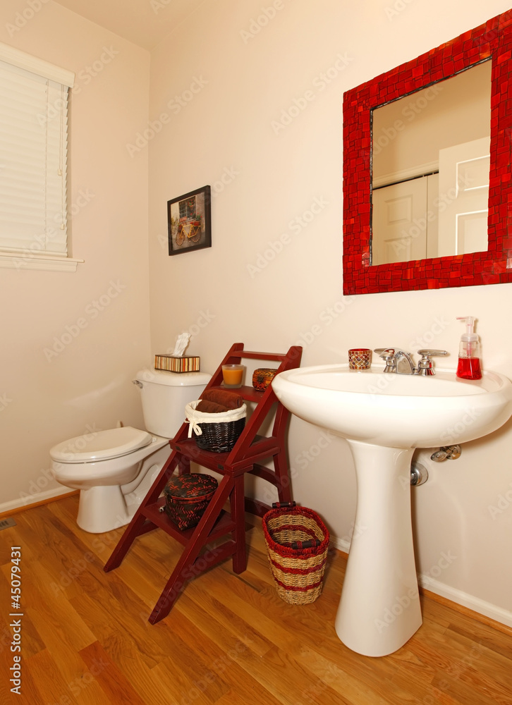 Fototapeta premium Small bathroom with sink and toilet and hardwood floor.