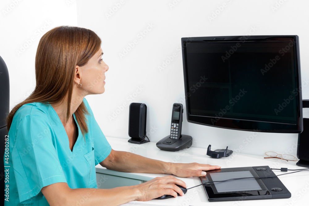 Female Dentist Using Computer - obrazy, fototapety, plakaty 