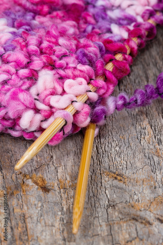 Colorful pink and purple knitting and wooden needles