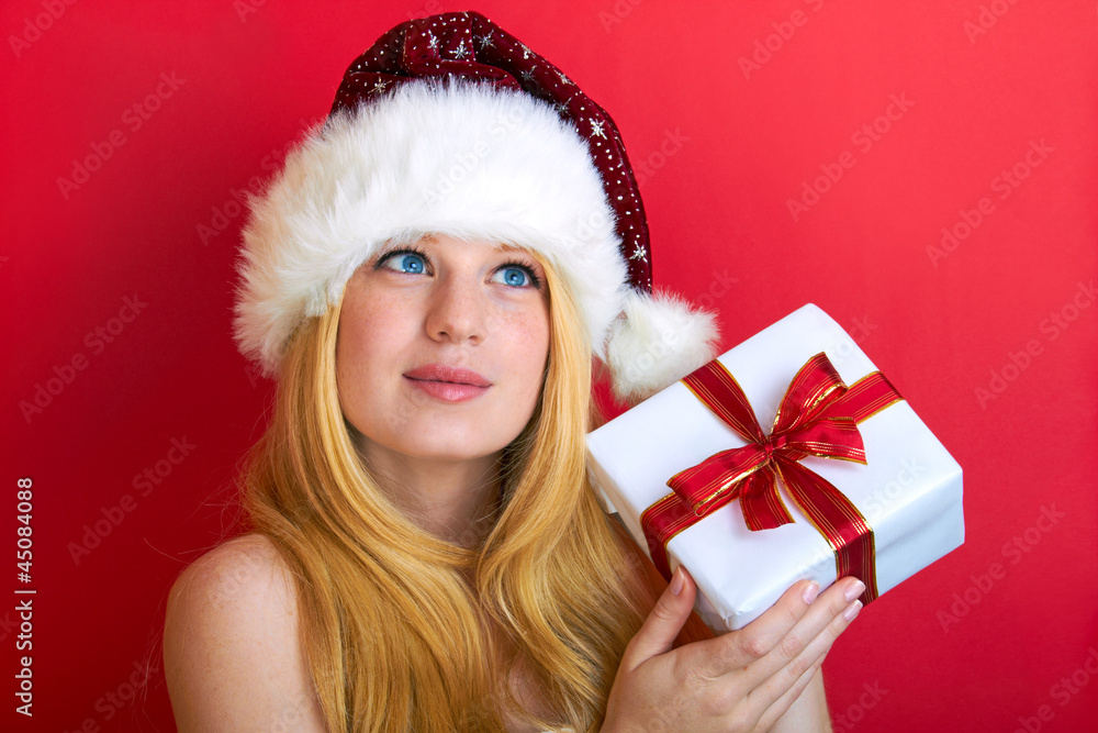 beautiful blonde woman holding a christmas gift is smiling beautiful blonde woman holding a christmas gift is smiling