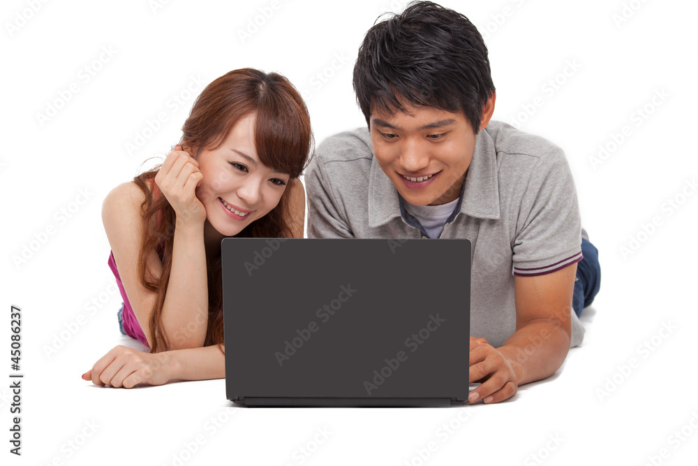 Happy couple using laptop isolated on white background.
