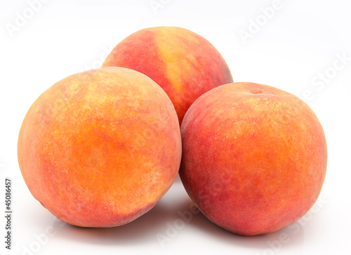 Three ripe peaches isolated
