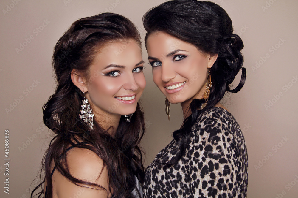 Two attractive smiling girls friends, sisters women studio shot Two attractive smiling girls friends, sisters women studio shot