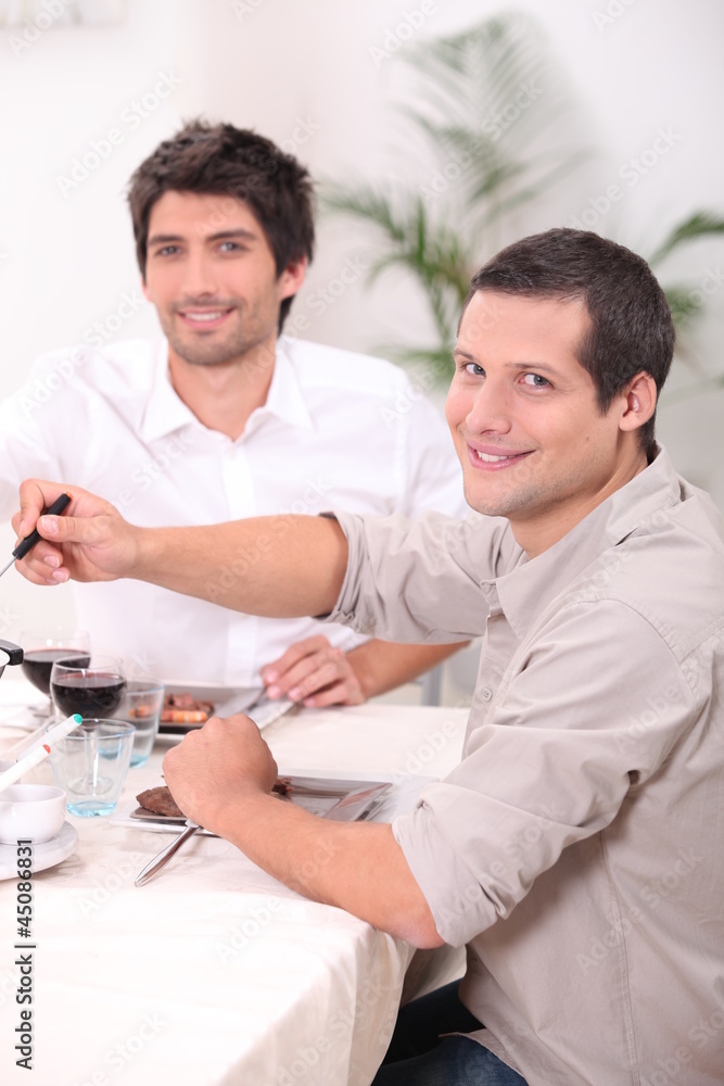 Fototapeta premium two young men having lunch