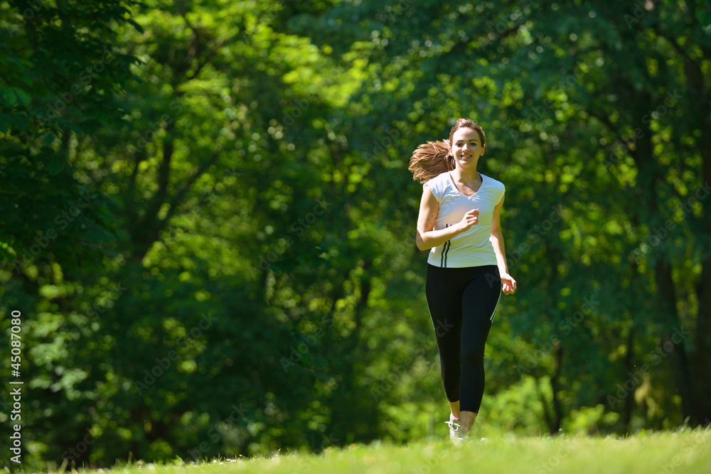 Young beautiful  woman jogging at morning in park