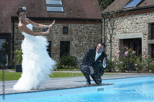 jeunes mariés au bord d' une piscine photo