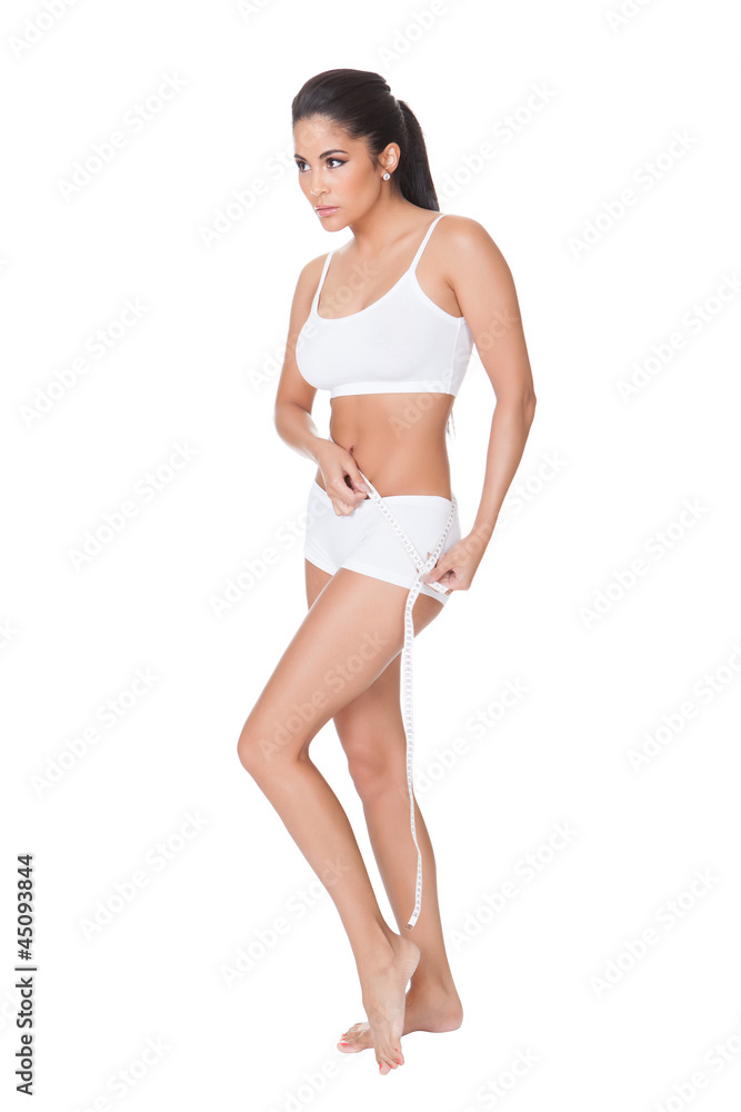 Shapely woman measuring her waist Shapely woman measuring her waist