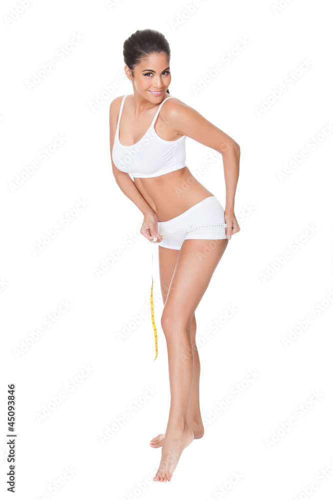 Shapely woman measuring her waist Shapely woman measuring her waist
