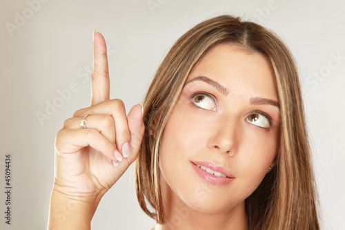 A young woman pointing at a copyspace