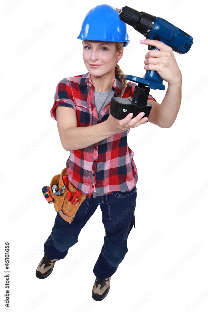Tradeswoman holding a battery-powered power tool Tradeswoman holding a battery-powered power tool