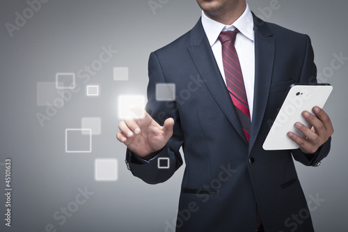 Businessman with tablet pushing on a touch screen interfac