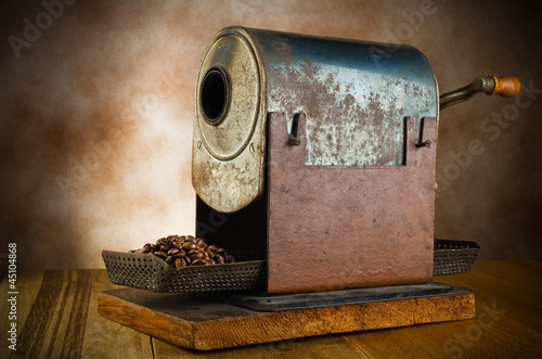 vintage roaster with coffee beans in the wood table photo