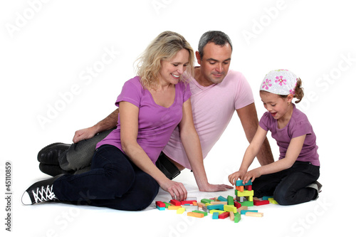 Parents and daughter playing building game