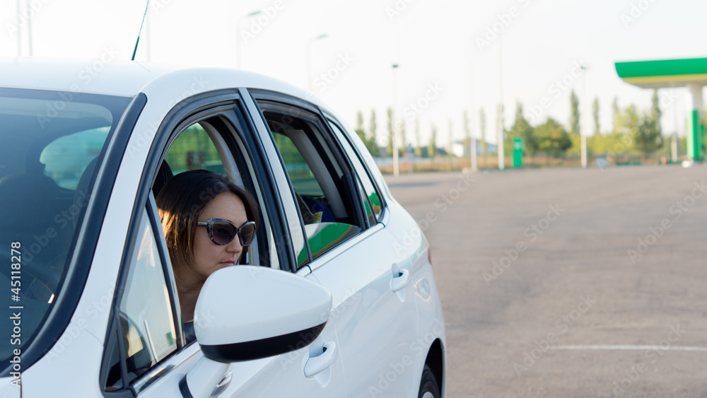 Female driver leaving a gas station