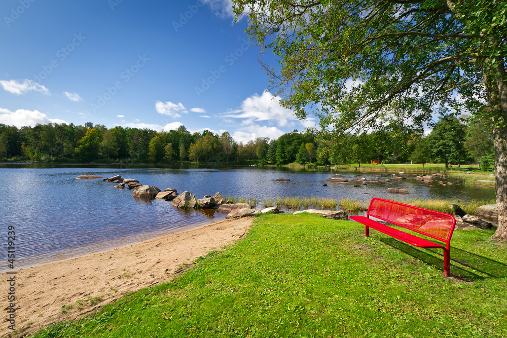Red bench at the lake in Kyrkhult, Sweden
