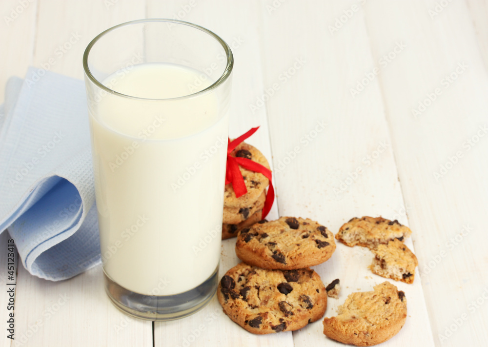 glass of milk and chocolate chips cookies with red ribbon glass of milk and chocolate chips cookies with red ribbon