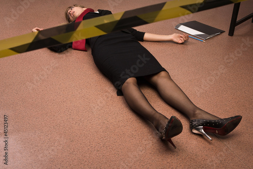 Lifeless business woman lying on the floor (imitation)