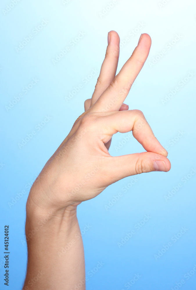Hand making sign on blue background Hand making sign on blue background