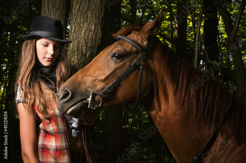 Cowgirl in hat with bay horse © Demian