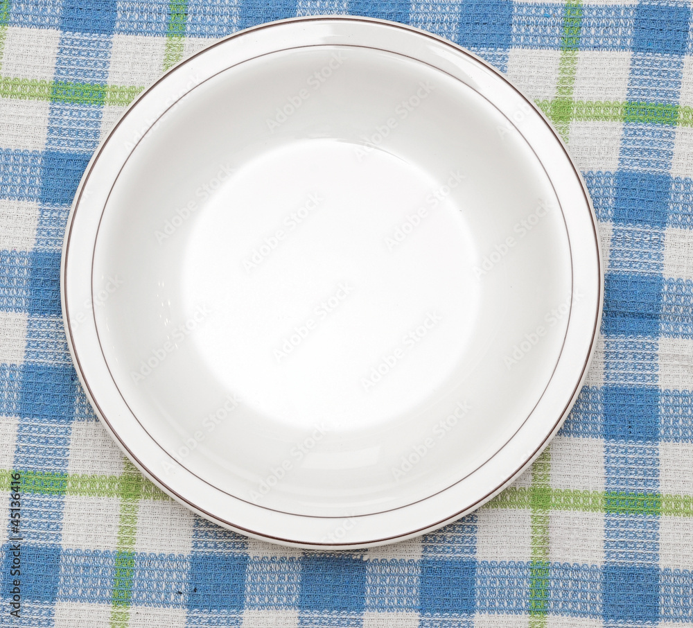 white plate on blue checked fabric tablecloth