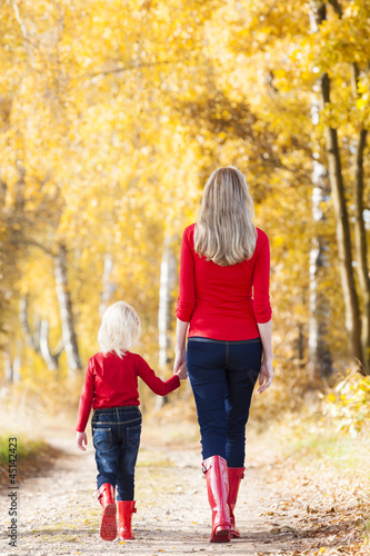 mother with her daughter in autumnal alley