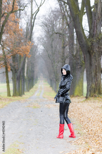 woman wearing rubber boots in autumnal alley © Richard Semik