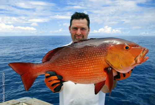 Pêcheur tenant une magnifique carpe rouge (red snapper) photo