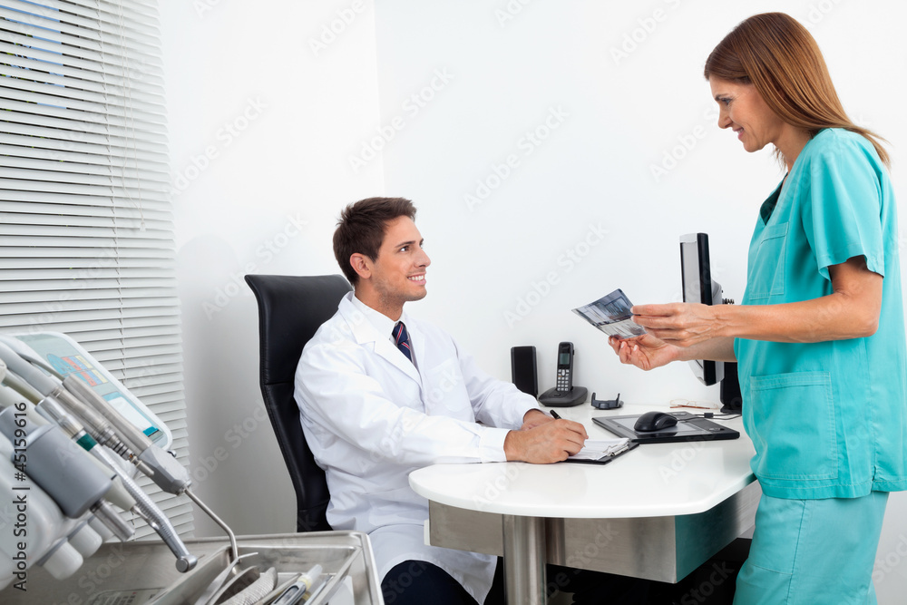 Doctor And Assistant With Dental Report Doctor And Assistant With Dental Report