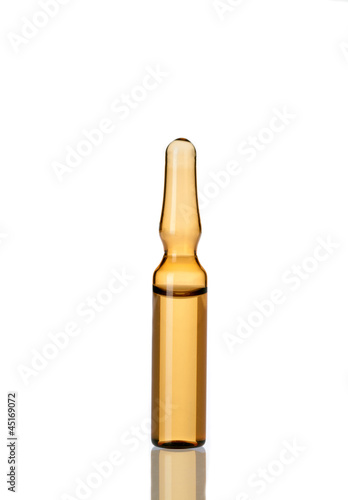 Close up view of yellow ampoule on white back