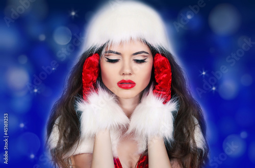 Santa girl listening to the music on blue background