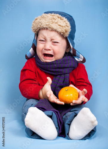 Плачущий мальчик с мандарином