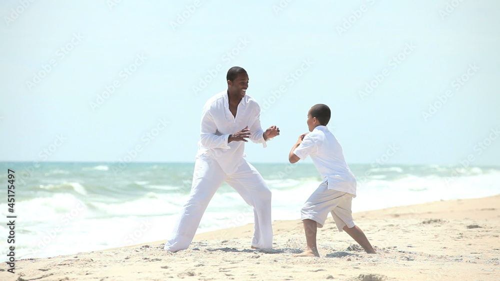 Ethnic father son playing American football Ethnic father son playing American football