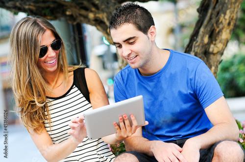 Attractive couple with tablet computer in urban background