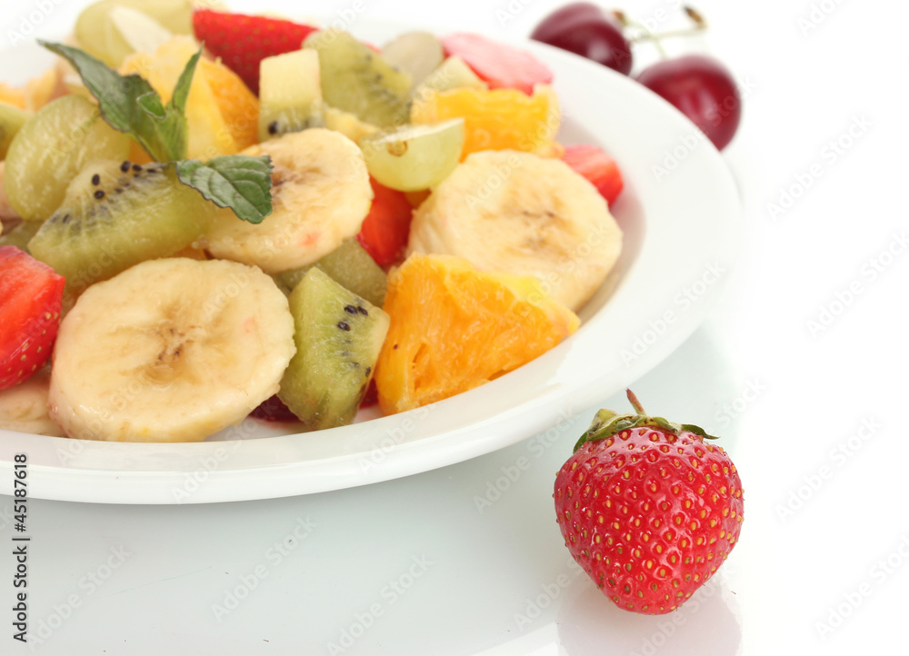 Fresh fruits salad on plate and berries isolated on white Fresh fruits salad on plate and berries isolated on white
