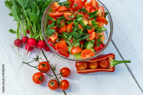 Fresh vegetables in sunny garden on old plank