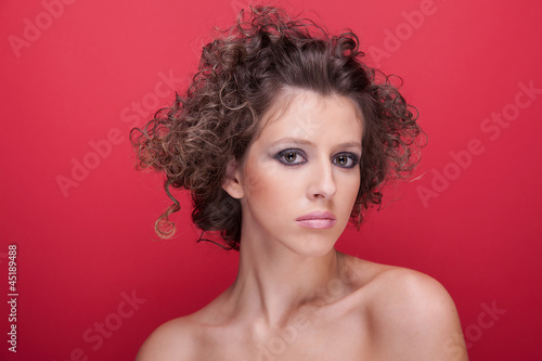 young and beautiful woman, with curly hair, on red