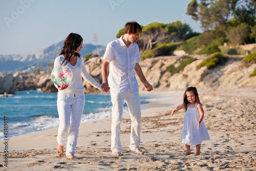 glückliche junge familie mit kleiner Tochter am Strand am wasse